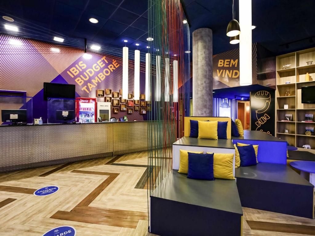 a bar with blue and yellow pillows in a store at ibis budget Tambore in Barueri