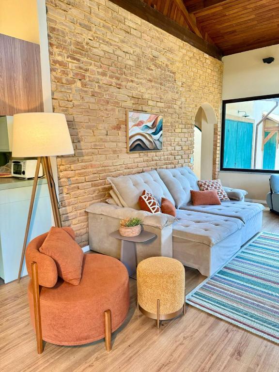 a living room with a couch and a brick wall at Casa com Jacuzzi e Área Gourmet em Mury in Nova Friburgo