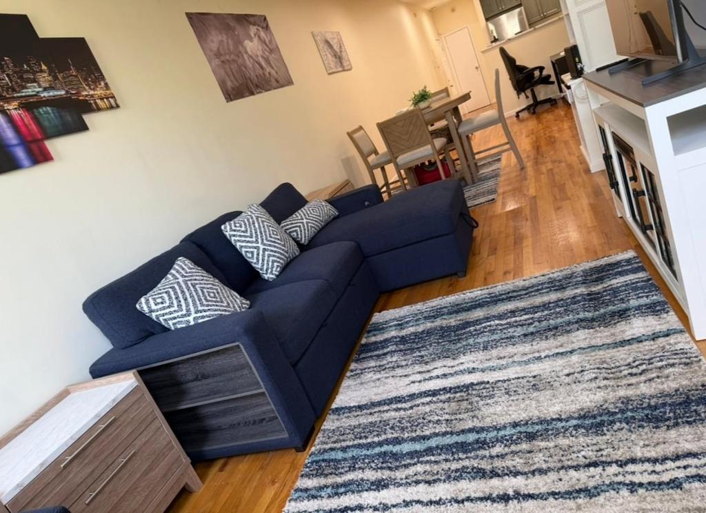 a living room with a blue couch and a rug at Weehawken Apartment NYC Skyline in Weehawken
