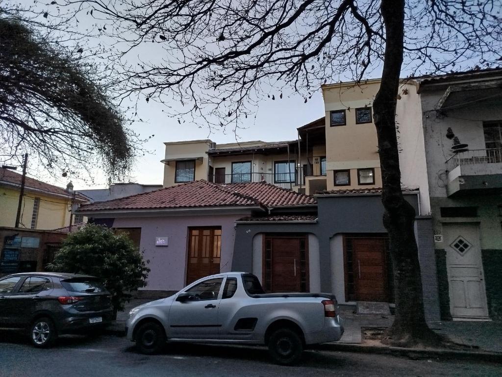 a white truck parked in front of a house at Vila Del Rei - Flat no Centro de São João Del rei in São João del Rei