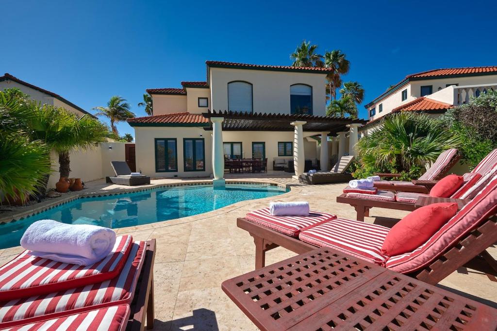 Villa con piscina y 2 sillas de jardín en Luxury 4BD Villa Tierra del Sol Private Pool, en Noord
