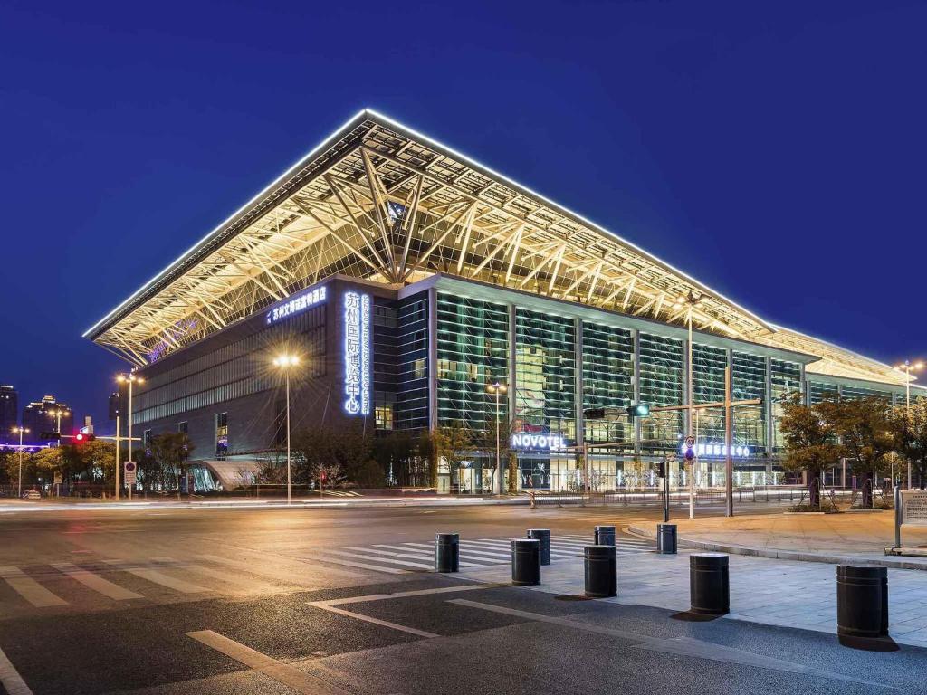 a large building in front of a parking lot at night at NOVOTEL Jinji Lake Suzhou SIP in Suzhou