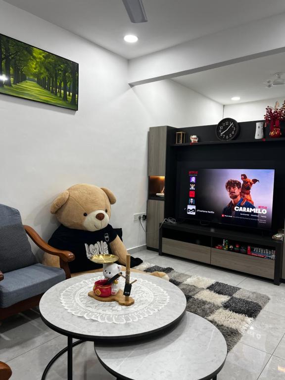 a teddy bear sitting in a chair in a living room at J&Y Homestay Kluang in Kluang