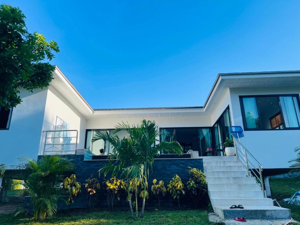 a house with stairs and plants in front of it at Casa Phangan - Boutique Island Villa in Wok Tum