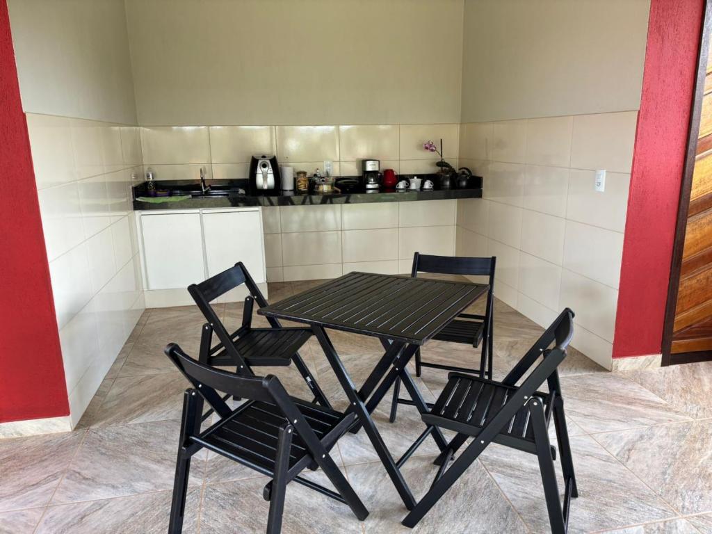 a table and chairs in a room with a kitchen at Tríade Chalé da Canastra 2 in São Roque de Minas