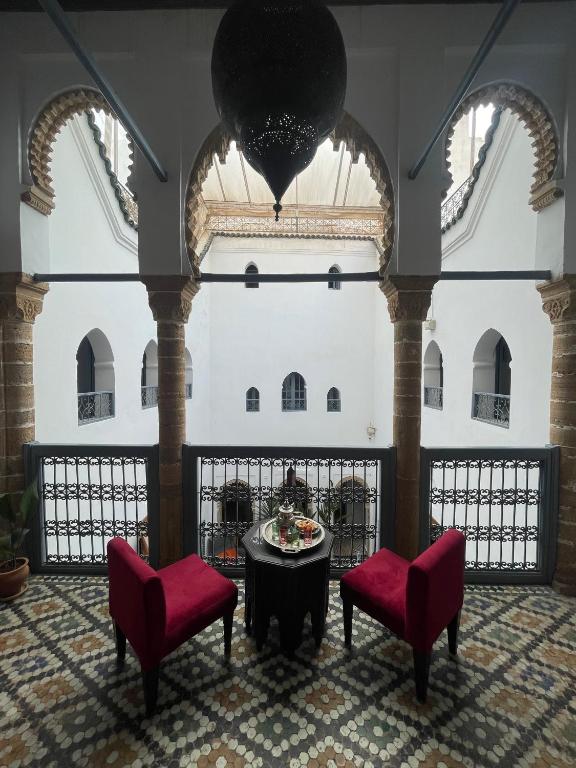 a room with two chairs and a table in a building at Riad Narjiss in Rabat
