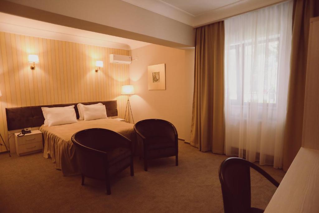 a hotel room with a bed and a window at C&C Residence Hotel in Bacău