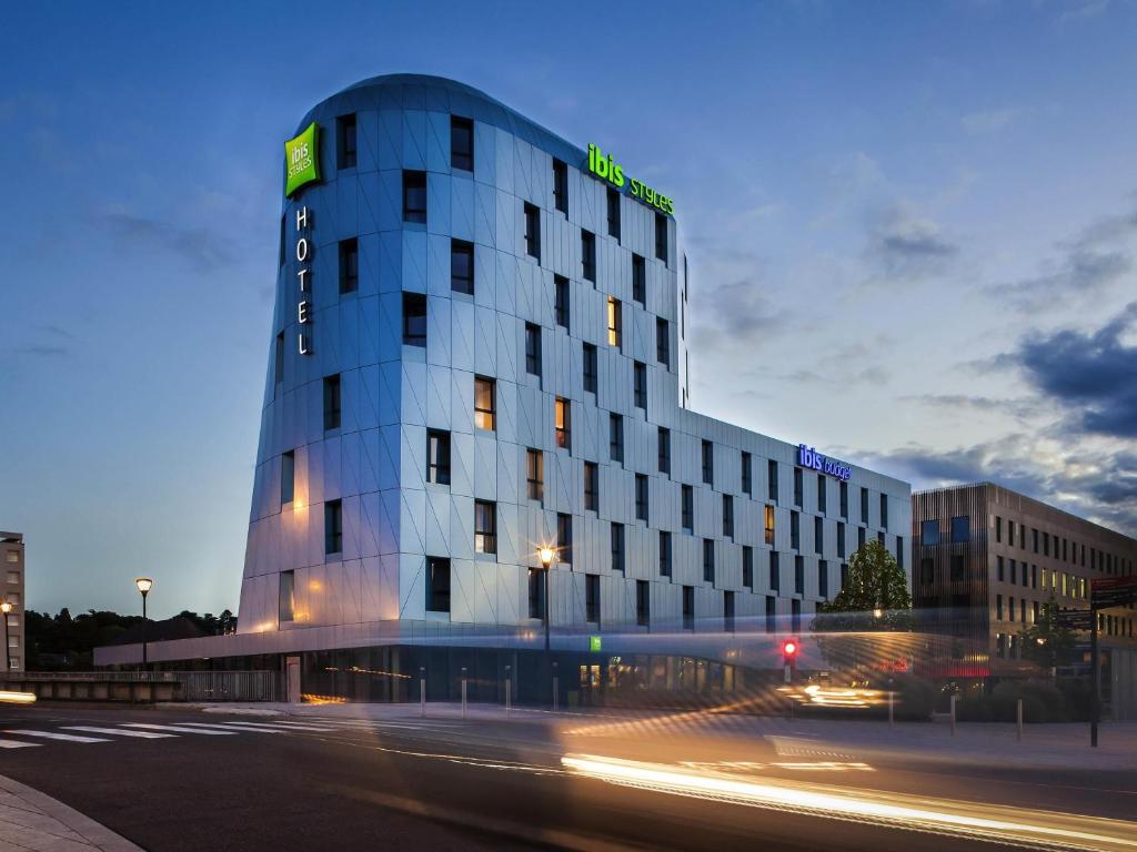 a building with a green sign on the side of it at Ibis Styles Mulhouse Centre Gare in Mulhouse