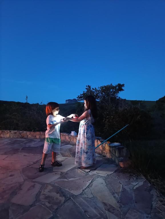 two young children are playing with a spear at Pousada Pé do Morro in Vale do Capao