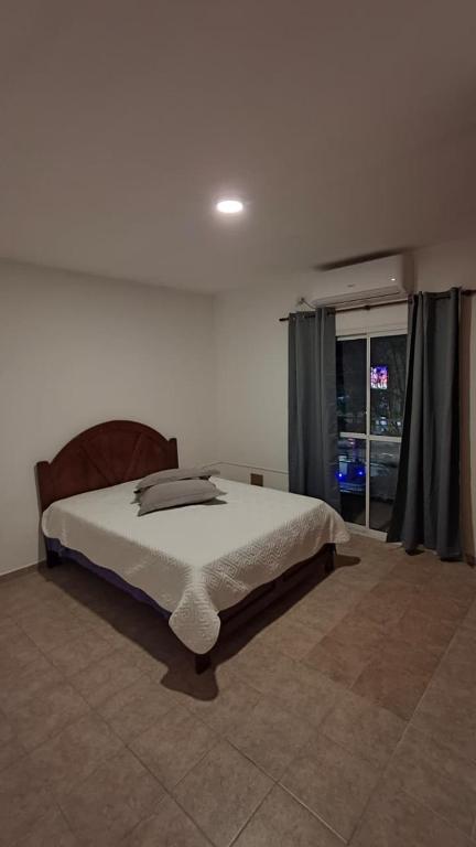a bedroom with a bed and a large window at La Plaza in Formosa