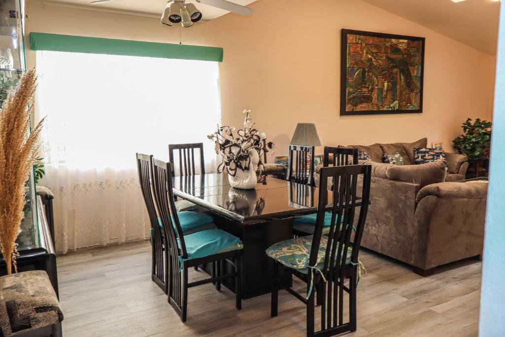 a dining room with a table and chairs and a couch at The Campeche Town House Townhouse in South Padre Island
