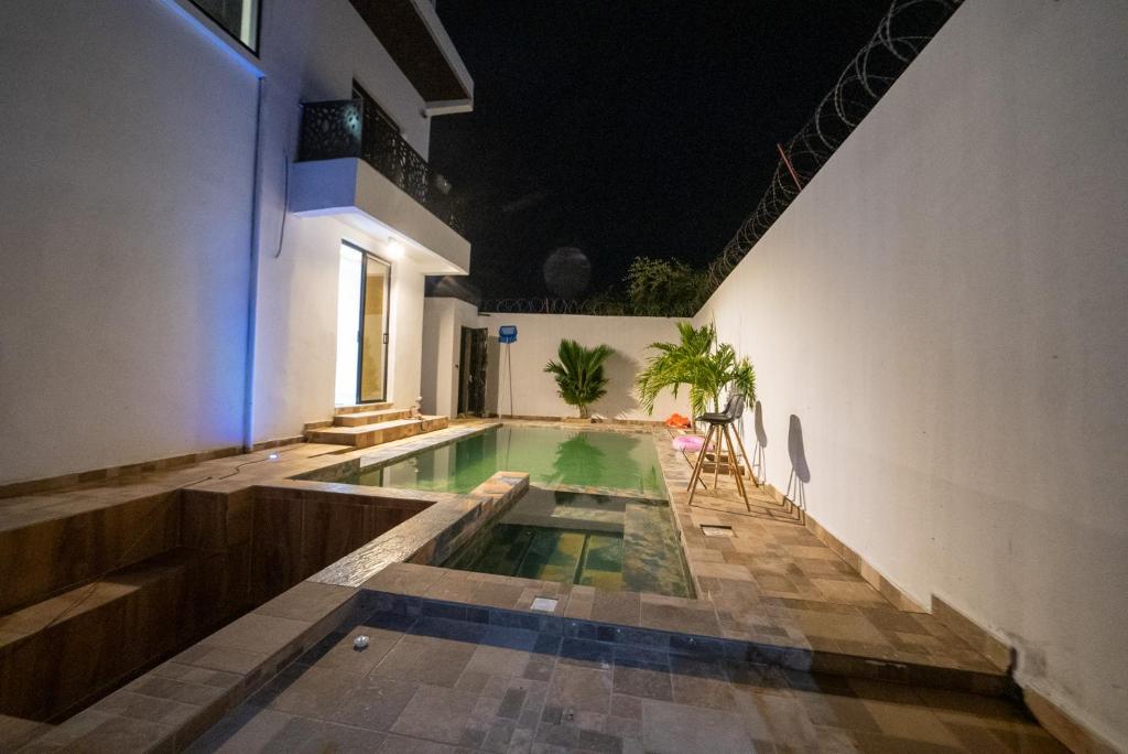 a swimming pool in the middle of a building at Villa serenité lac rose avec cuisinier ,piscine et jacuzzi terrasse vue lac in Ouayembame