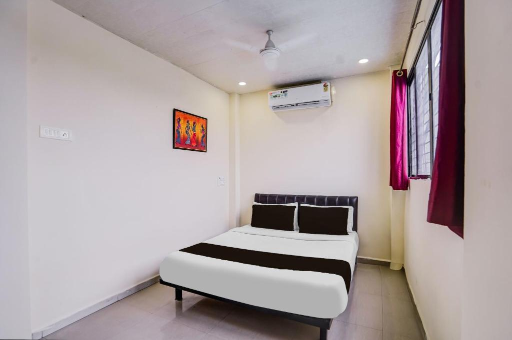 a small bedroom with a bed and a window at HOTEL O REGAL INN in Dhantoli