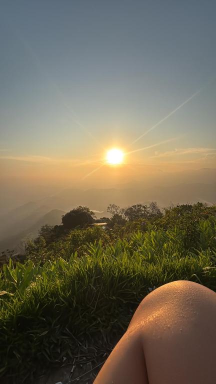 a person sitting on a hill watching the sunset at Beco 6 in Petrópolis