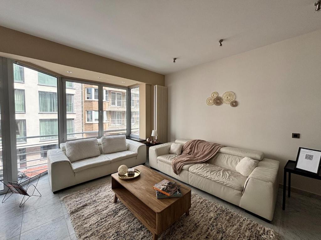 een woonkamer met een bank en een salontafel bij Spacious and comfortable apartment in Knokke-Heist