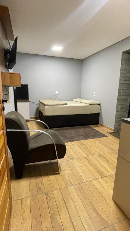 Habitación con cama y silla. en Quarto Próximo 15min perto Aeroporto Guarulhos, en Guarulhos