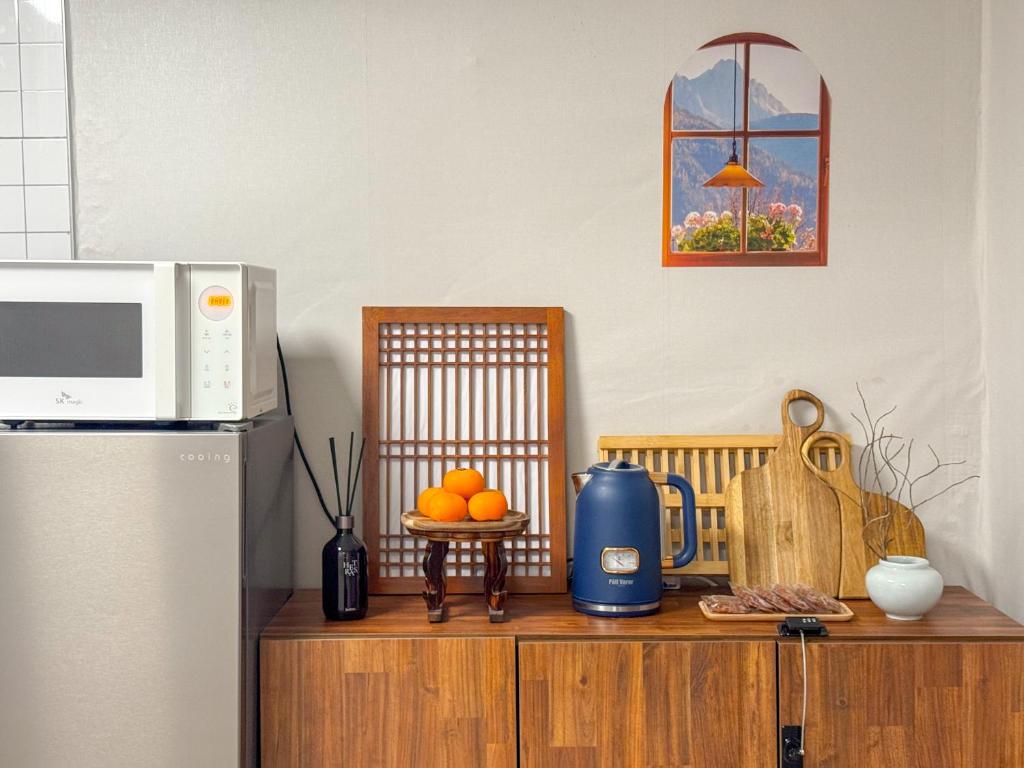 a kitchen counter with a microwave and some fruit on it at Oknuri in Seoul