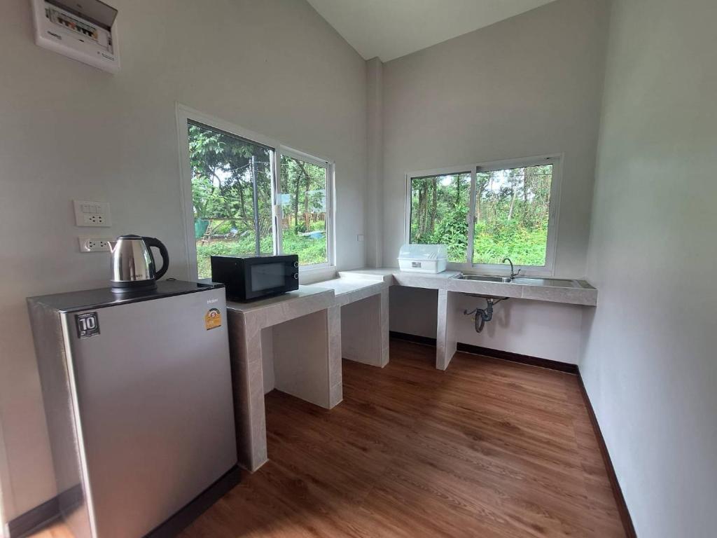 una pequeña cocina con 2 lavabos y nevera en Phu Aunna, en Ko Phayam