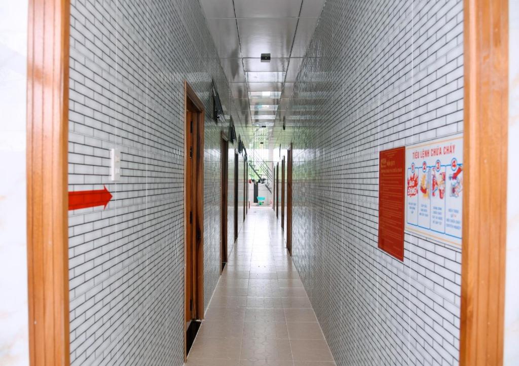 a hallway with white walls and a long corridor at Nhà Nghỉ Hoa Mười Giờ in Tân Tạo