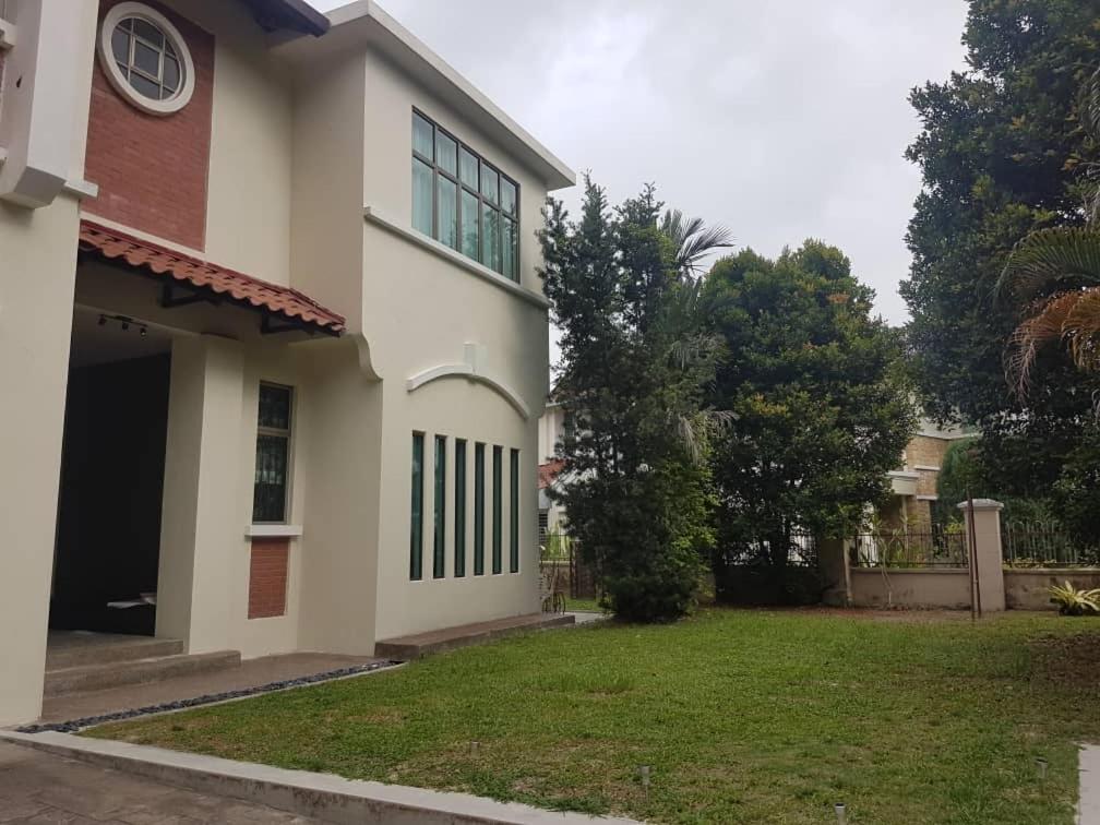 a house with a lawn in front of it at CalOlie Villa in Shah Alam