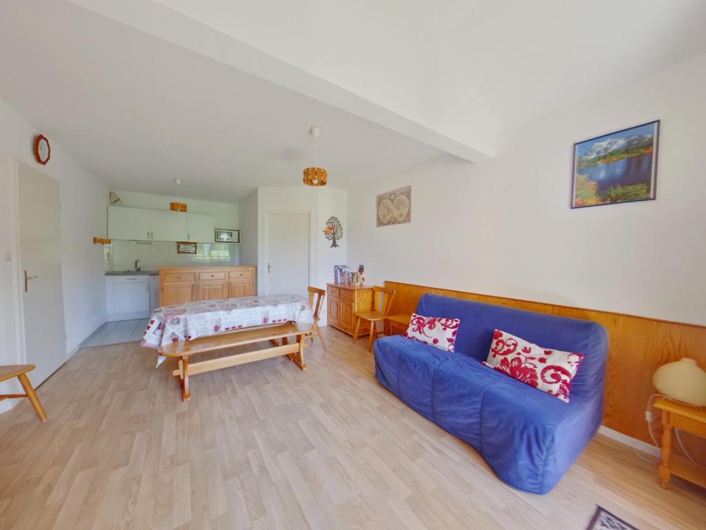 a living room with a blue couch and a table at Appartement confortable au pied des pistes - 6 pers - FR-1-834-14 in Prémanon