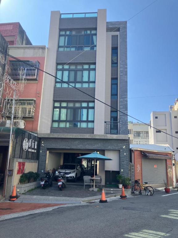 Un edificio alto con una mesa y una sombrilla delante. en 杉行居, en Lukang