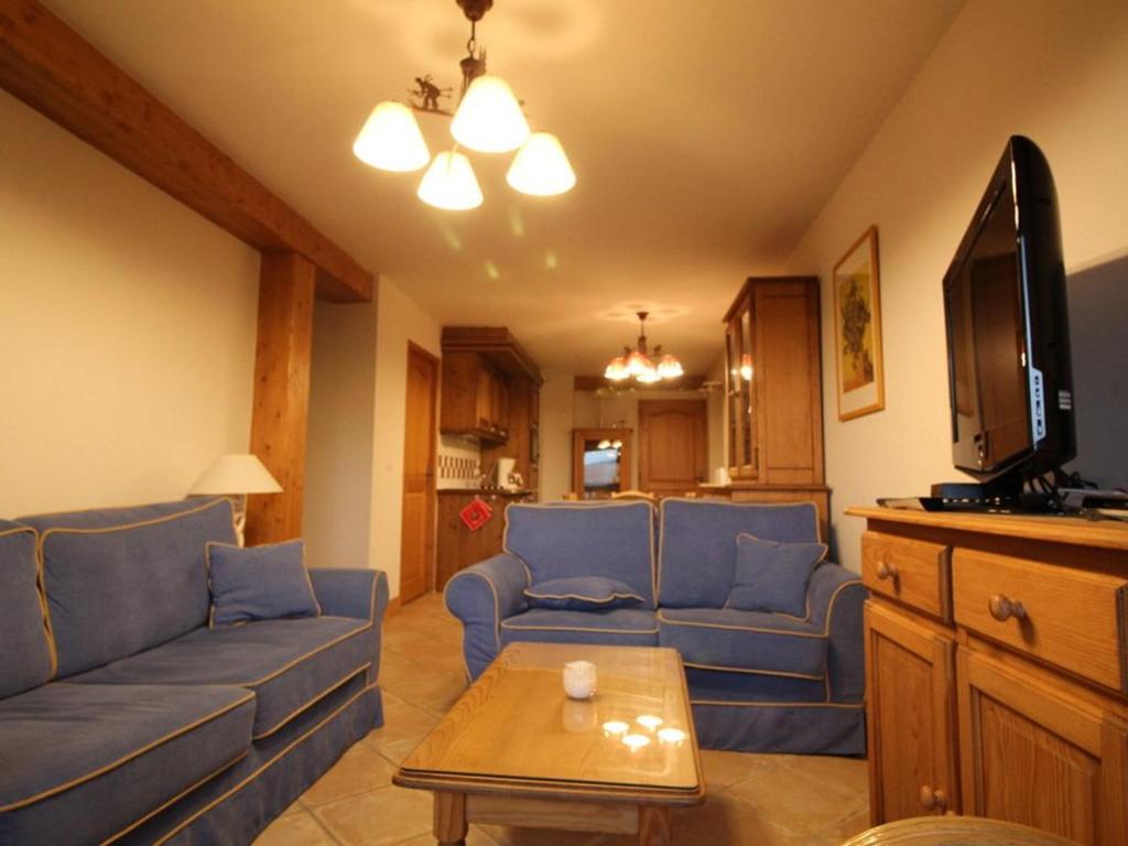 a living room with blue couches and a table at Appartement 4 pièces 8 pers rénové avec parking aux Carroz d'Arâches - FR-1-572-335 in Arâches-la-Frasse