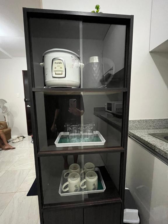 a shelf with cups and a toaster in a kitchen at 2 Bedroom Condo Fully-Furnished good for 5-6pax by Gerra at Urban Deca Homes Banilad in Mandaue City
