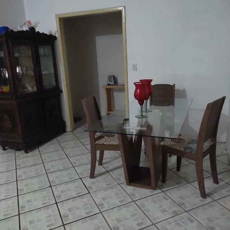 een eettafel met stoelen en een rode lamp erop bij Casa com vista para o mar in Santa Cruz Cabrália