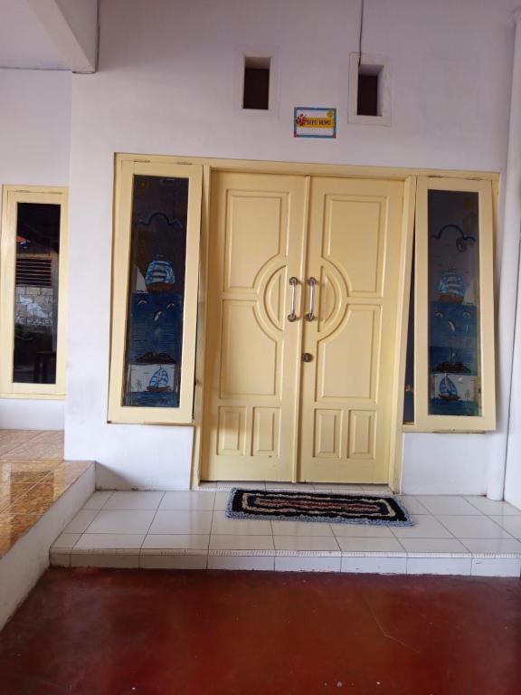 a pair of doors in a room with a tile floor at homestay in Ketapang