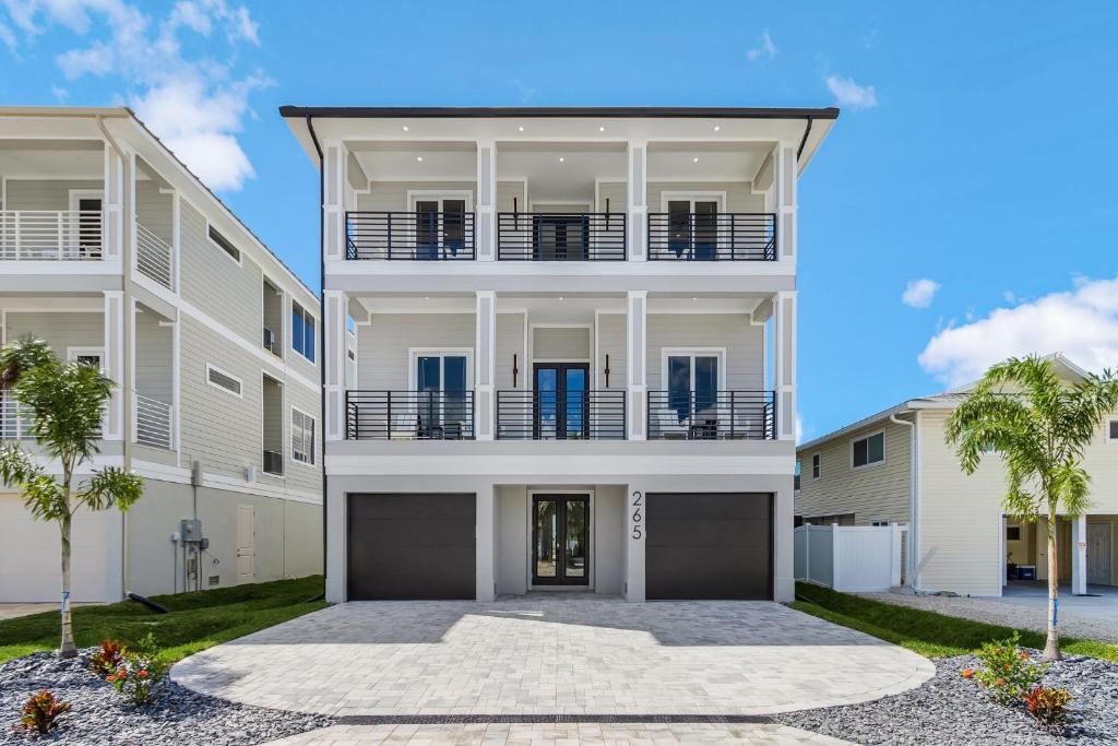 a large white building with palm trees in front of it at 141 Brand New Luxury 6BR 6BA Build with Heated Pool! home in Fort Myers Beach