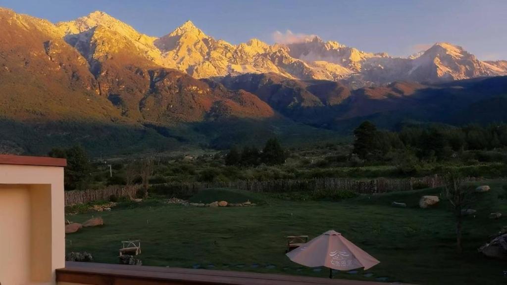 a view of a mountain range with an umbrella at Yunshui Shenshen Rizhao Jinshan Panoramic Secret Resort Hotel in Lijiang