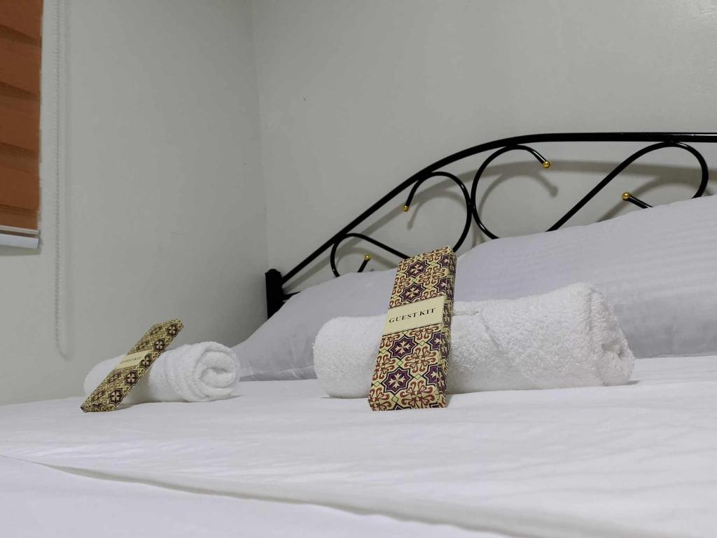a bed with towels and ties on top of it at CasaCavite - Your Chill Hideaway and Mini-Resort Just Minutes from all the Tagaytay-Silang-Nuvali Action! in Silang