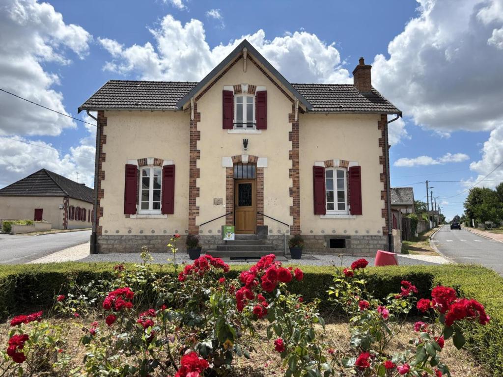 Una casa con persianas rojas en una calle con flores. en Gîte familial en campagne paisible, 8 pers, tout inclus - FR-1-489-589, en Saligny-sur-Roudon