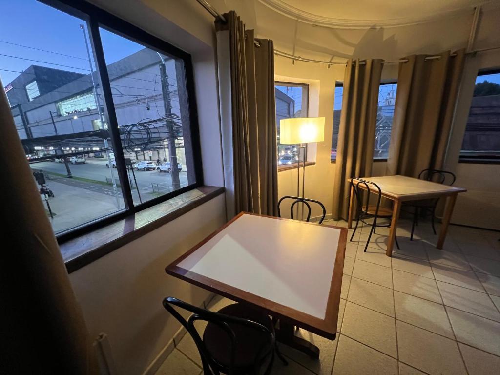 une table et des chaises dans une pièce avec une fenêtre dans l'établissement Sky Aloja Hotel - Frente al Mall de Osorno, à Osorno