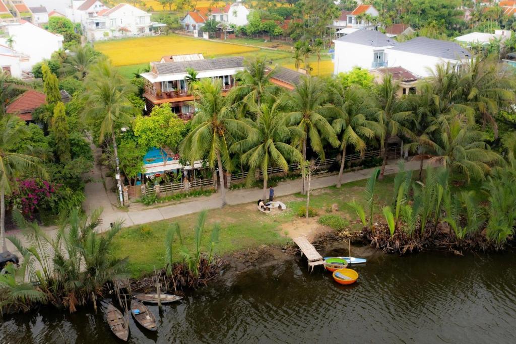 会安Laoxao RiverStone Villa的棕榈树环绕的房屋的鸟瞰图