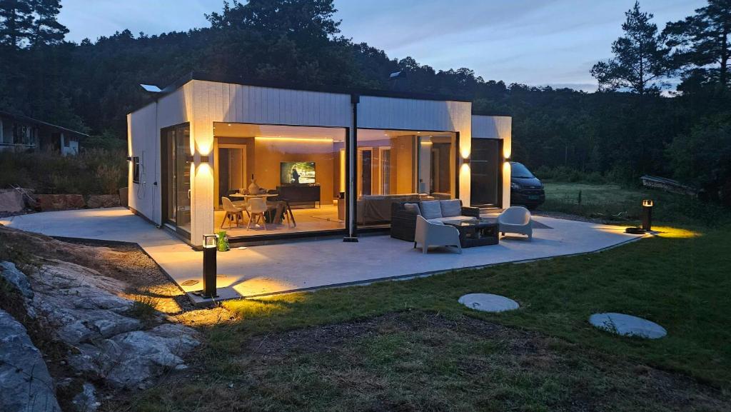 a small house with a lot of glass at Cabin With Sea Views Near Kristiansand in Hamresanden