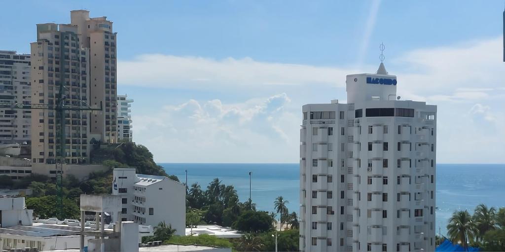 a tall white building with the ocean in the background at Mar & Sierra El Rodadero Apto Vista al Mar Piscina & Playa in Rodadero