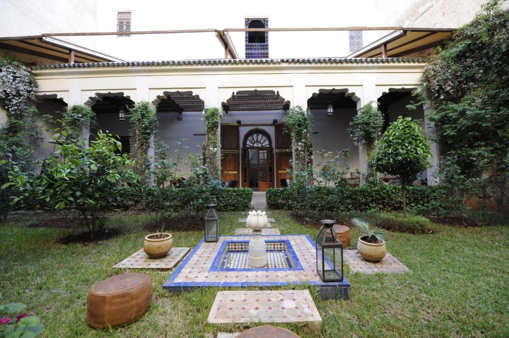 a house with a garden with a table in the yard at Riad Au 20 Jasmins in Fès