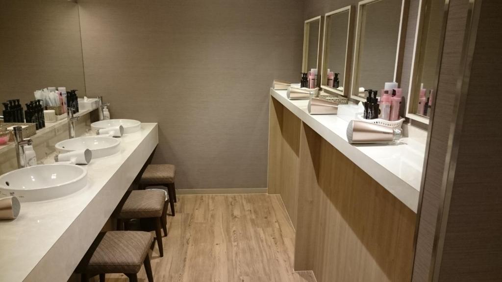 La salle de bains est pourvue de 3 lavabos et de 2 miroirs. dans l'établissement Gran Customa Isezakicho, à Yokohama