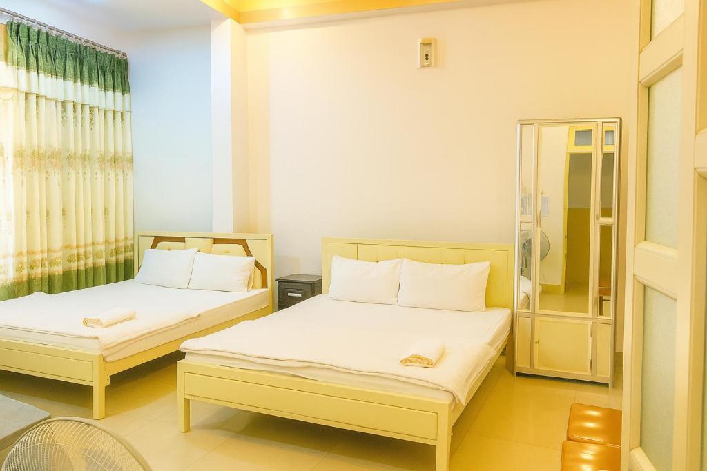 a bedroom with two beds and a window at Nam Dương 3 Hotel in Phan Rang