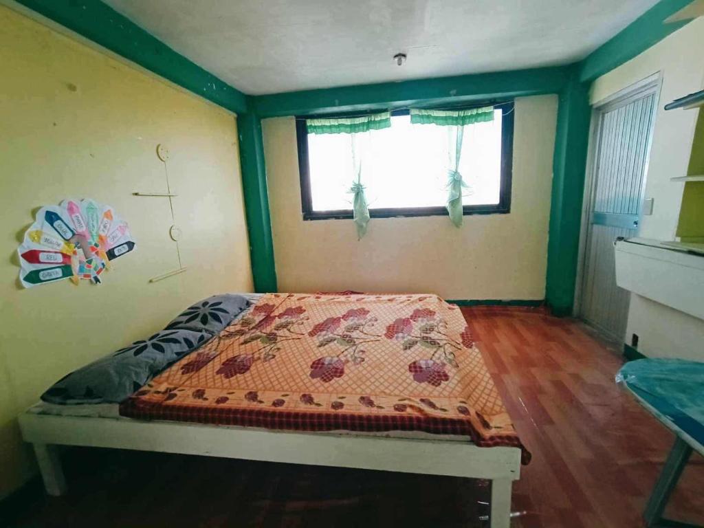 a bedroom with a bed in a room with a window at Mountain Pine Breeze in Sampong