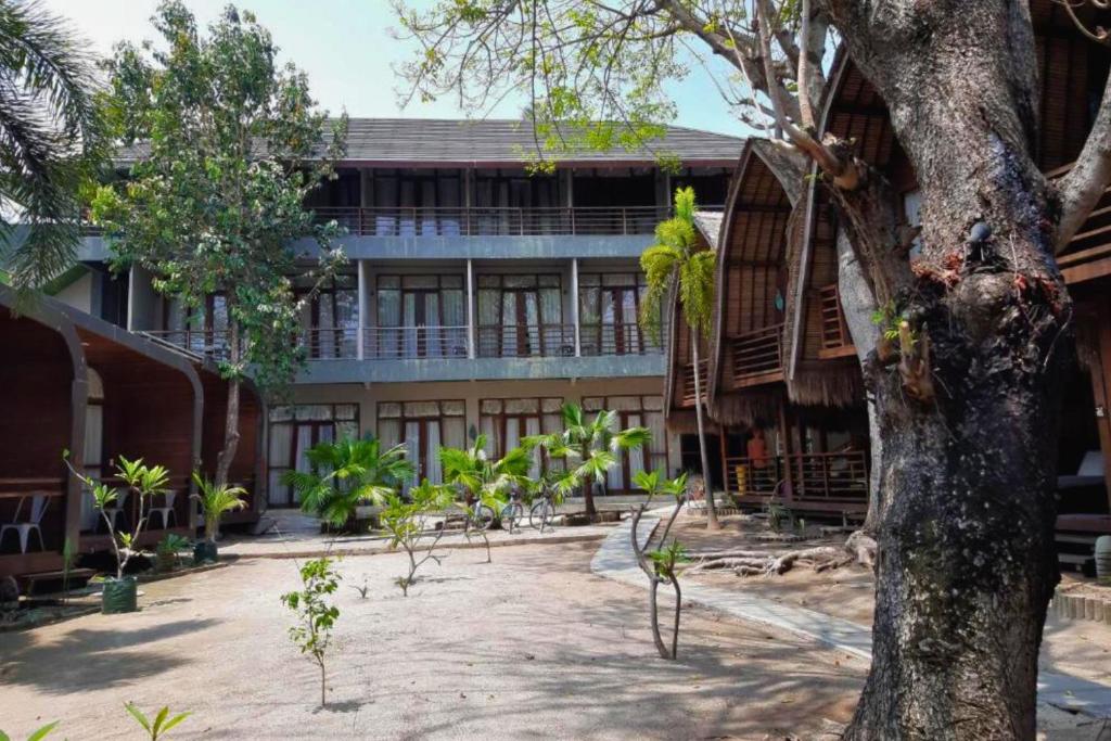 ギリ・アイルにあるCindra 1 BR Deluxe Room Gili Air NE59の前に木がある建物