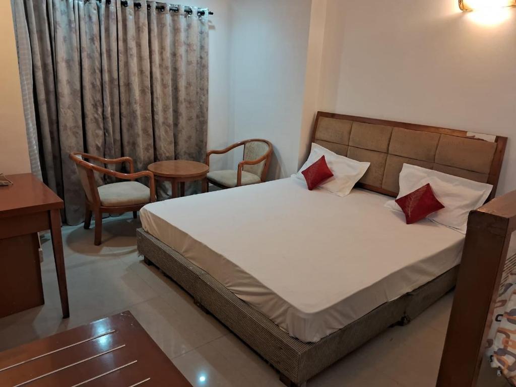 Un dormitorio con una cama y una mesa y sillas. en Kishori homeste, en Vrindāvan