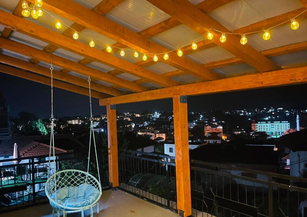 a patio with a chair and lights on a balcony at Apartmani E&A Jasmina Okanović in Gradačac