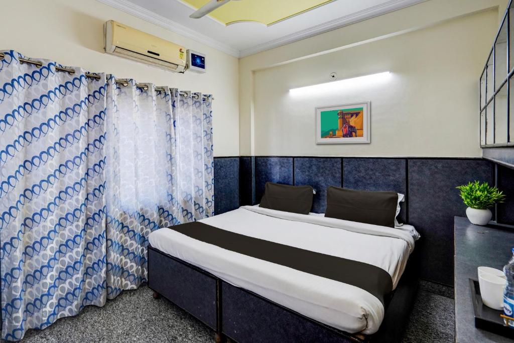 a bedroom with a bed with a blue and white curtain at Hotel O Aryan Home Stay in Dehradun