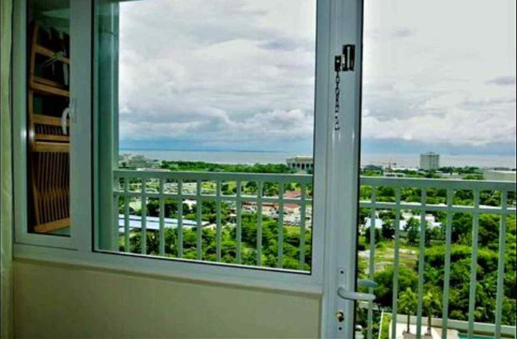 a window with a view of a city at Breeze Staycation by Charmed in Sampong