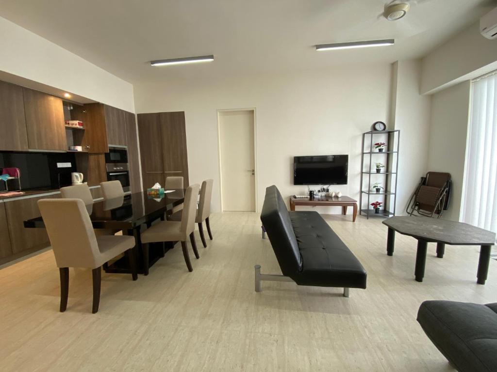 a living room with a table and a dining room at By The Sea @ Cozy Beachfront Home in Batu Ferringhi