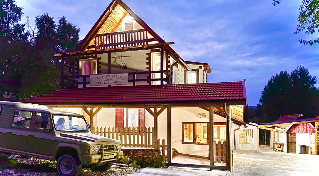 a house with a car parked in front of it at Cabana Cristi Paul Ianosiga in Teregova