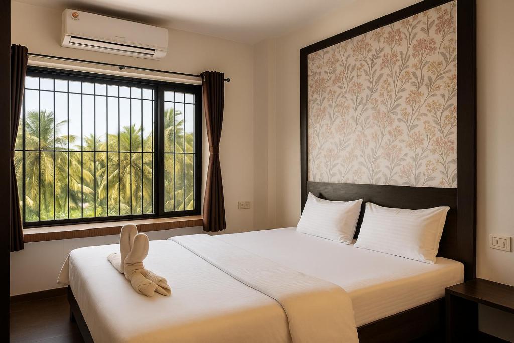 Un dormitorio con una cama y una ventana grande. en The Grantley Hotel, en Alībāg